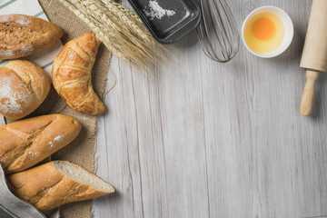 fresh bread and wheat on sack and wooden table.