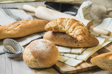 fresh bread and wheat on sack and wooden table.