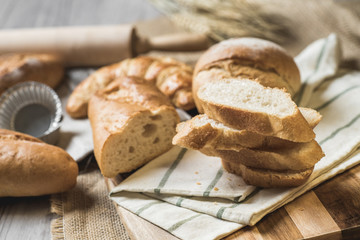 fresh bread and wheat on sack and wooden table.