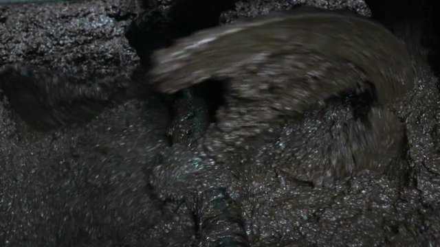 Traditional olive oil processing with crushing the olives into a paste