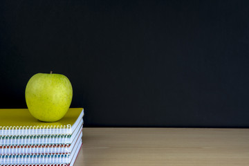manzana sobre los  cuadenos y pizarra vacía, regreso a la escuela