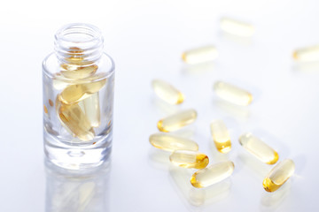 Omega 3 capsules in a glass bottle close up on the white background
