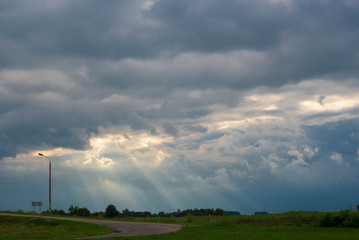 Fototapeta na wymiar View on the rays of the sun shine trough dark clouds