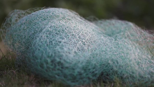 Blueish small nit net on grass.