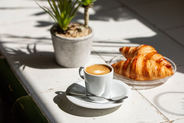 Hot coffee and croissant breakfast in a sunny morning, natural light. - 217172610