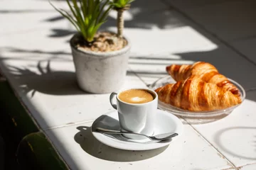 Türaufkleber Hot coffee and croissant breakfast in a sunny morning, natural light. © funkyfrogstock