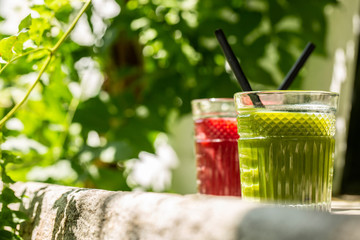 Red and green detox juice glass  with copy space in a sunny outdoors