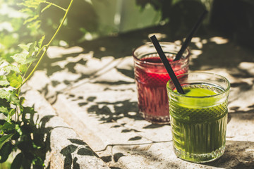 Red and green detox juice glass  with copy space in a sunny outdoors