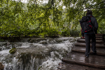 Croazia, 28/06/2018: uomo di spalle su una passerella di legno nel Parco nazionale dei laghi di Plitvice, uno dei parchi più antichi dello stato al confine con la Bosnia Erzegovina