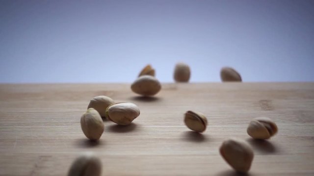 Slow motion of pistachios on wooden background