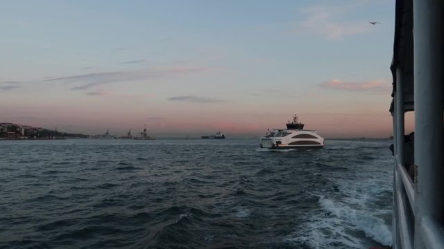 Wide angle shot of ferry going from Europe to Asia in Istanbul's Bosphorus during sunset(slow motion)