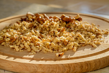 On a cutting board finely chopped walnuts for eat cooking. Closeup view.