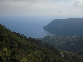 An amazing caption of the beautiful places from the 5 Terre in Liguria with an amazing blue sky and some green mountains in the background