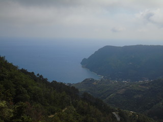 An amazing caption of the beautiful places from the 5 Terre in Liguria with an amazing blue sky and some green mountains in the background