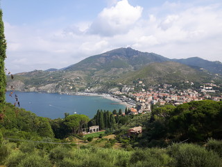 An amazing caption of the beautiful places from the 5 Terre in Liguria with an amazing blue sky and some green mountains in the background