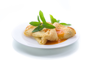 sweet thin pancakes with jam in a plate