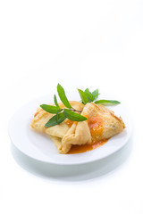 sweet thin pancakes with jam in a plate