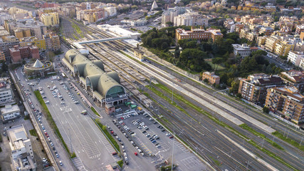 Obraz na płótnie Canvas Aerial view of the Ostiense station in Rome, Italy. There are many tracks, rails and tourists passing by the station. At the bottom we see the Cestia Pyramid.