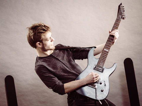 Young man playing electric guitar