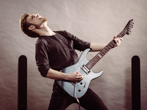 Young man playing electric guitar