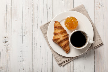 Breakfast with croissant, coffee and orange jam