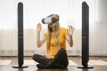 Girl wearing virtual reality goggles at home