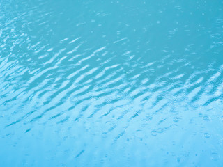 Rippling blue water by rain background