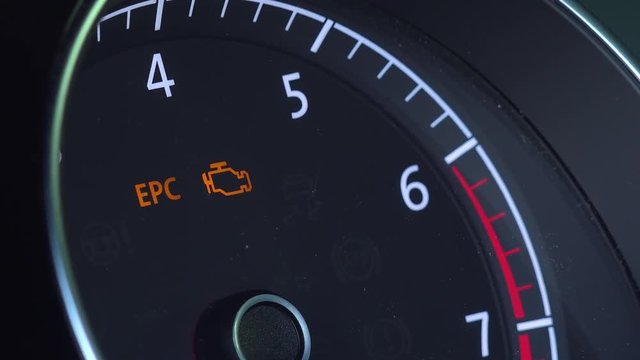 Closeup on a car tachometer with icon of engine 