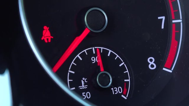 Closeup on a car tachometer with icon of seat belt 
