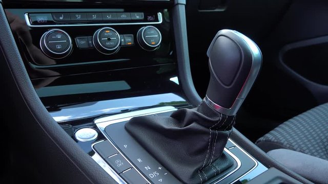 A man moves a gearshift to manual mode in a car - closeup