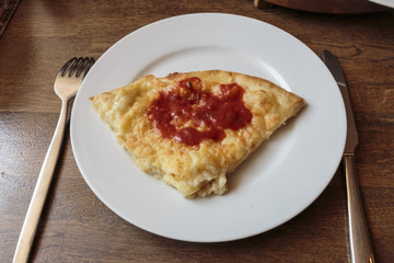 Slice of tasty cheese pizza on a white plate in a restaurant, Italian traditional appetizer.