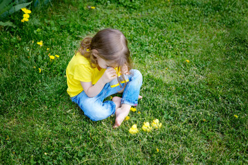 cute little girl playing with rubber duck and plastic binoculars outdoors. beautiful baby having fun with a toy duckling. home development of children. selective focus.	