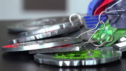 Closeup on a pile of medals from races on a table