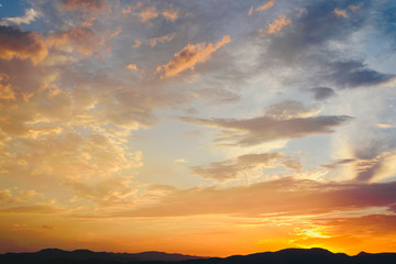Beautiful sunset with the sun of orange tones behind the mountains and deep blue sky