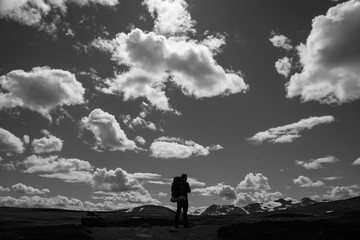 Fototapeta premium Hiker standing below dramatic clouds