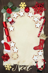 Christmas blank letter to Santa Claus or party invitation concept with Noel sign, gingerbread biscuits, winter flora and decorations on parchment on oak background.