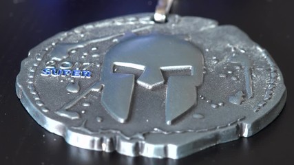 Closeup on a medal from a Spartan Super dirty race on a table