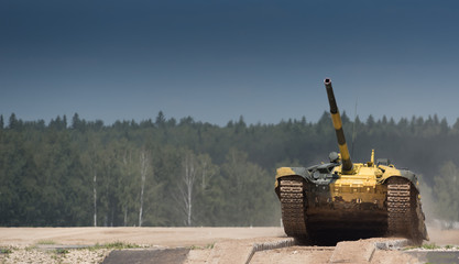 Military or army tank ready to attack and moving over a deserted battle field terrain. a lot of...