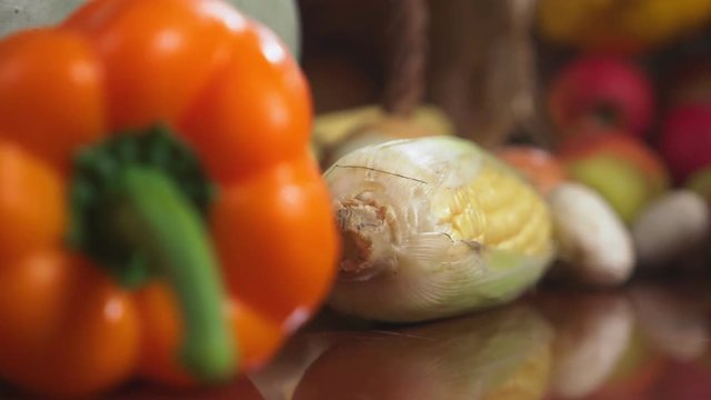 Autumnal Harvest or Thanksgiving, Cornucopia filled with vegetables, vegetables spilled out of the basket on the table. 4k, dolly shot