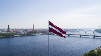 Panorama of Riga city with a big Latvian flag in foreground - obrazy, fototapety, plakaty