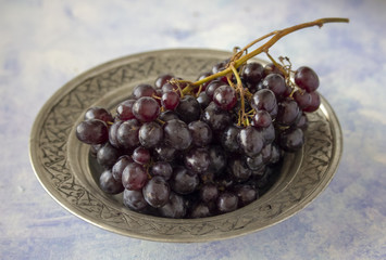 Black grapes in silver bowl