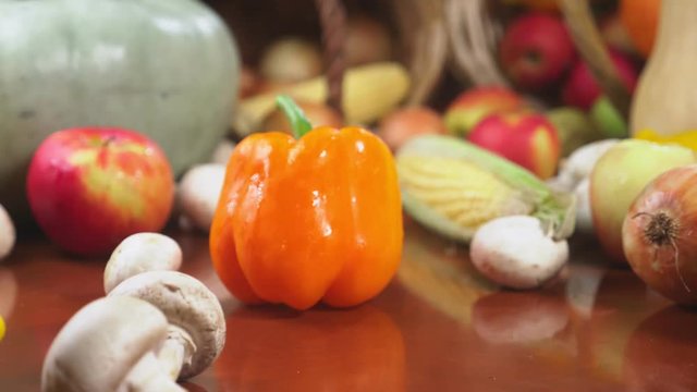 Autumnal Harvest or Thanksgiving, Cornucopia filled with vegetables, vegetables spilled out of the basket on the table. 4k, dolly shot