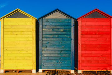 Cabins changers for bathers on a beach of the Mediterranean in summer, colored blue, yellow and red.