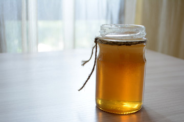 Honey in a transparent jar on the table