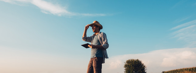 Farmer agronomist with tablet computer in bare empty field