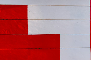 Detail of red cross on white wooden table.