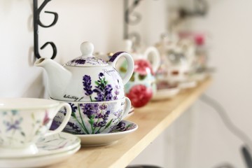 old tea pots and cups on a shelf