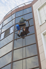 Industrial climber washes windows of an office building