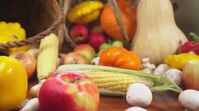 Autumnal Harvest or Thanksgiving, Cornucopia filled with vegetables, vegetables spilled out of the basket on the table. 4k, dolly shot