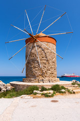 Fototapeta na wymiar Historic windmill overlooking Mandrakia port. Rhodes island, Greece